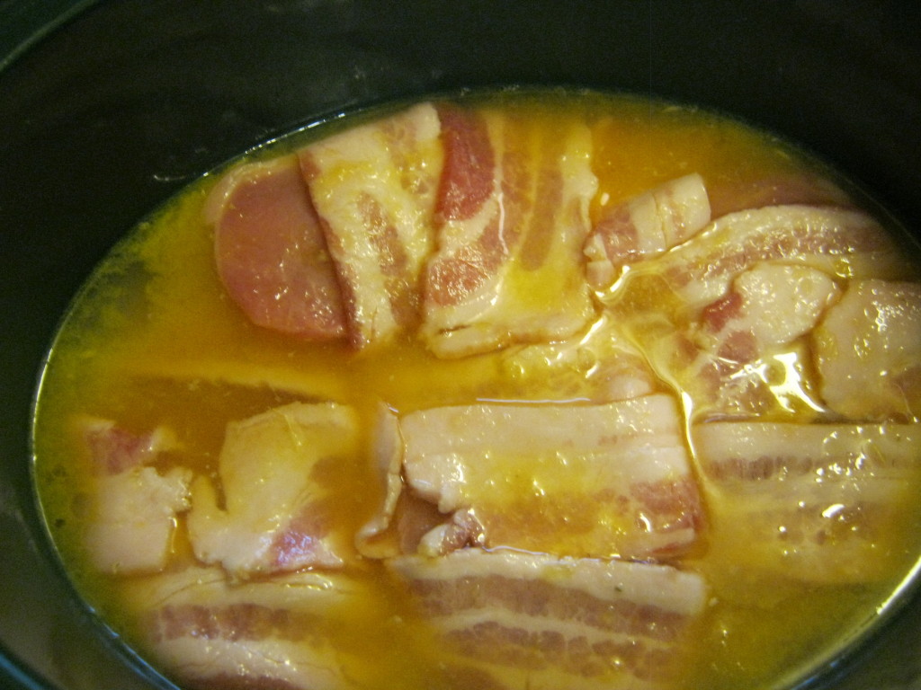 Bacon wrapped pork chops in orange juice in a Crock Pot